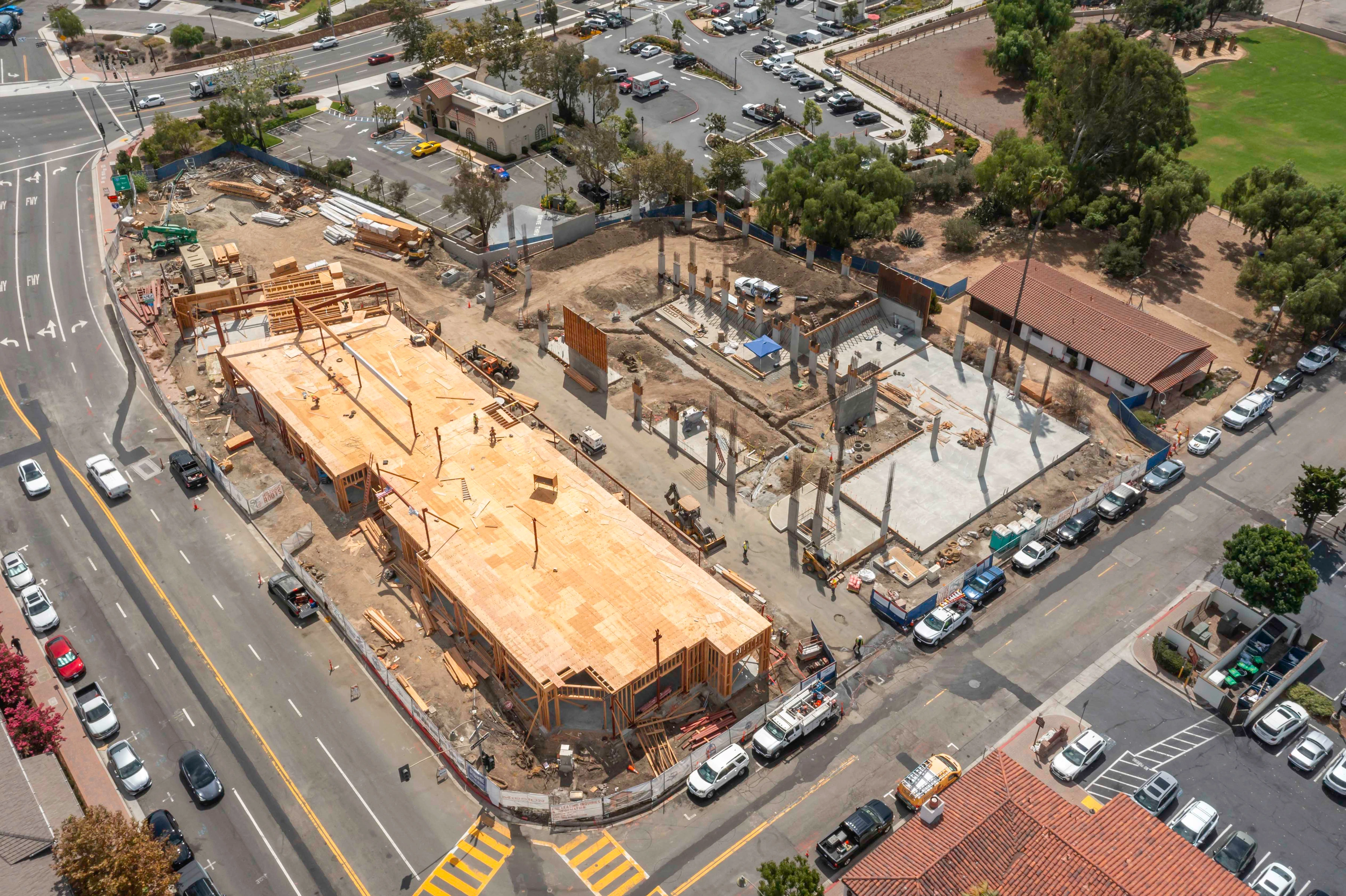 Elevated oblique view of Mission Place with an exposed wood-framed deck at left and concrete slabs with upright columns at right.